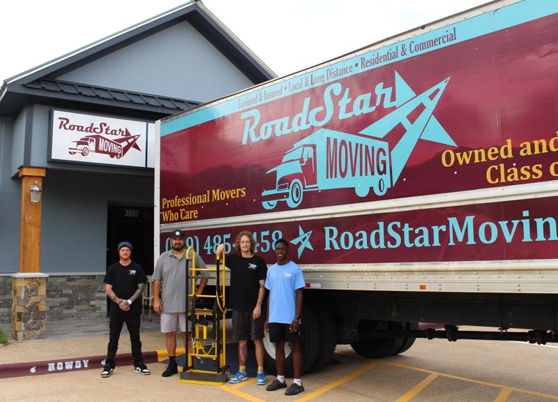 4 male standing in front of a trailer.
